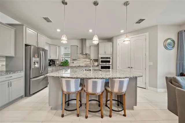 a kitchen with kitchen island granite countertop lots of white cabinets stainless steel appliances lots of white furniture