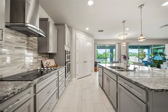 a kitchen with stainless steel appliances granite countertop a sink stove and cabinets