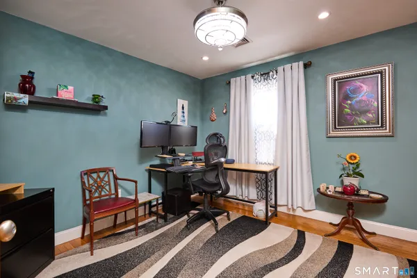 a view of a workspace with furniture and a window