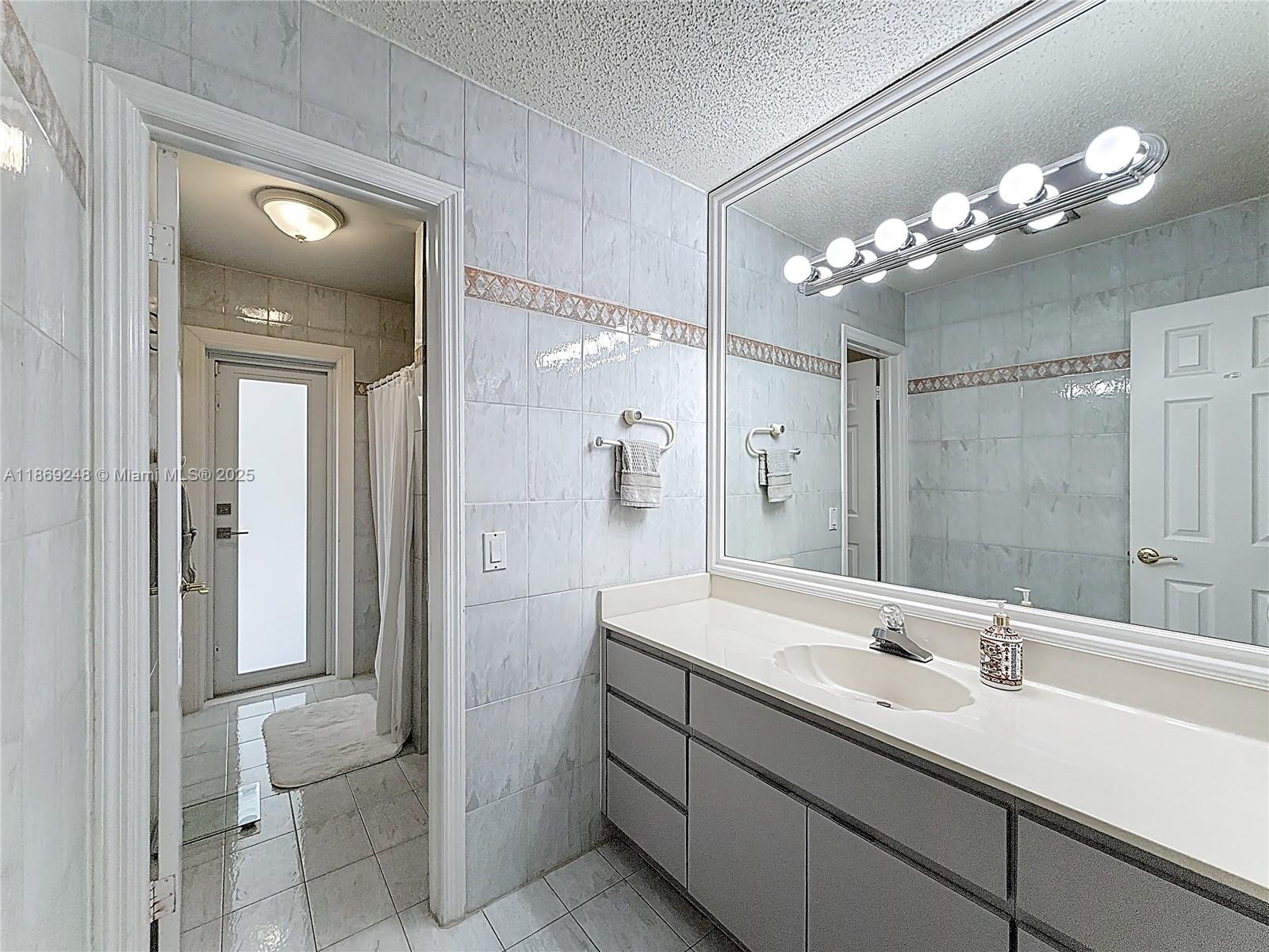10462 Southwest 121st Street Miami, FL 33176 - Photo 14 of 35 a bathroom with a double vanity sink mirror and shower