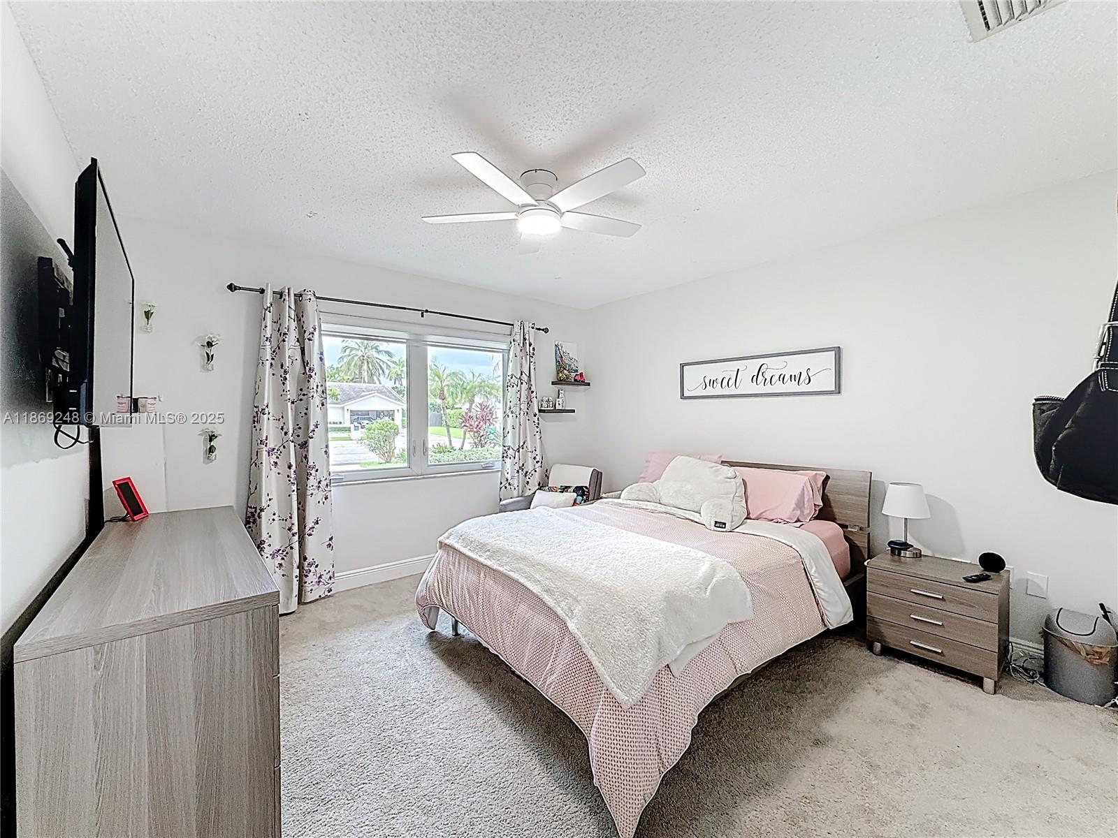 10462 Southwest 121st Street Miami, FL 33176 - Photo 15 of 35 a bedroom with a bed flat screen tv and windows