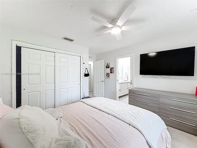 a bedroom with a bed tv and a window