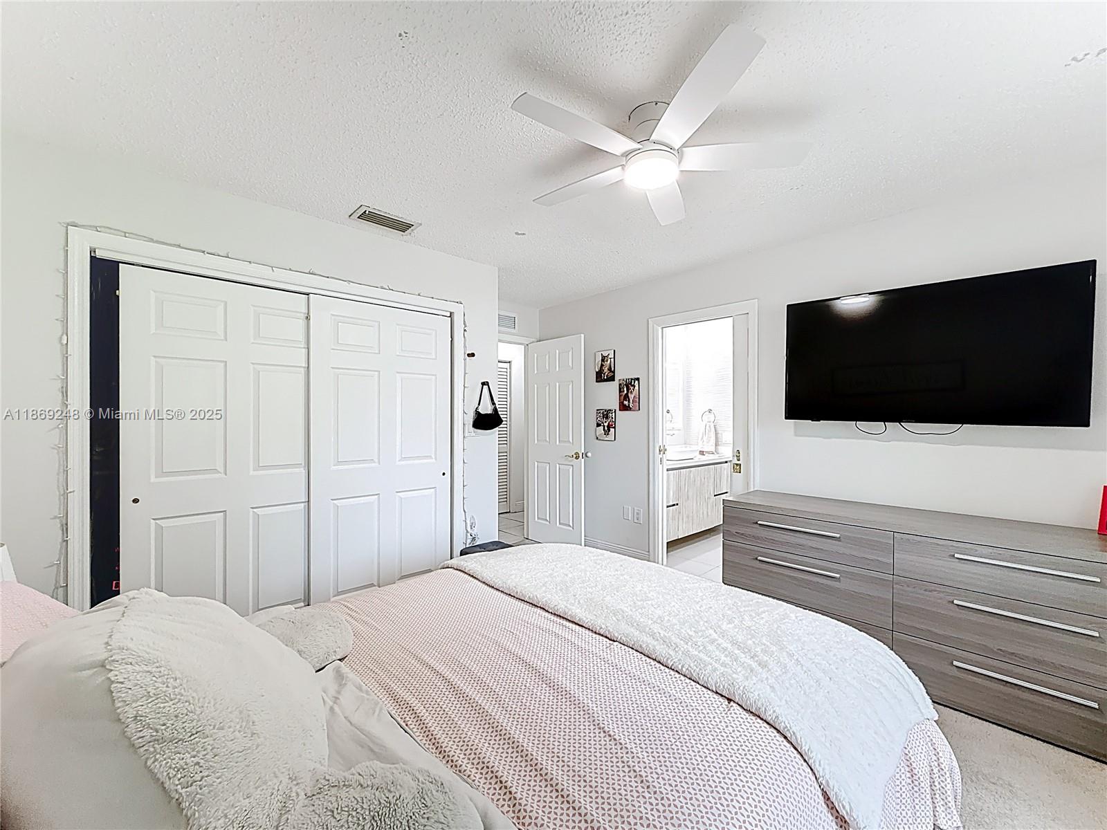 10462 Southwest 121st Street Miami, FL 33176 - Photo 16 of 35 a bedroom with a bed tv and a window