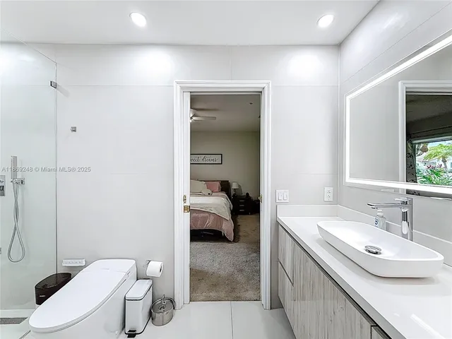 a en suite bathroom with a granite countertop toilet sink and mirror