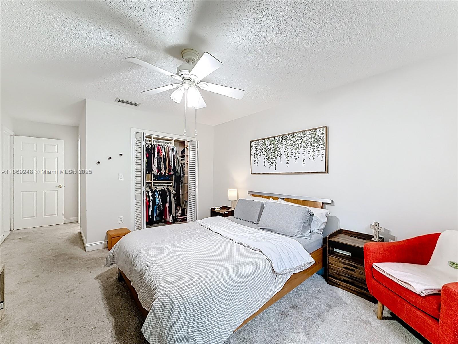 10462 Southwest 121st Street Miami, FL 33176 - Photo 19 of 35 a bedroom with a large bed and a chandelier