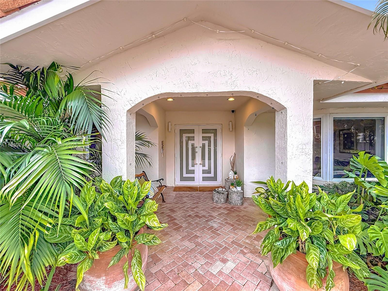 10462 Southwest 121st Street Miami, FL 33176 - Photo 2 of 35 a front view of a house with a flower garden