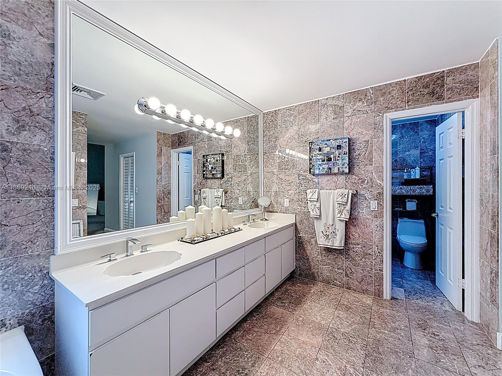 10462 Southwest 121st Street Miami, FL 33176 - Photo 26 of 35 a bathroom with a double vanity sink mirror and toilet