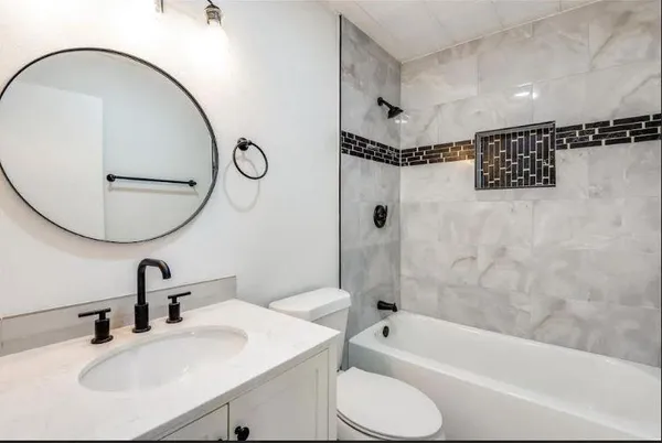a bathroom with a sink toilet and a mirror