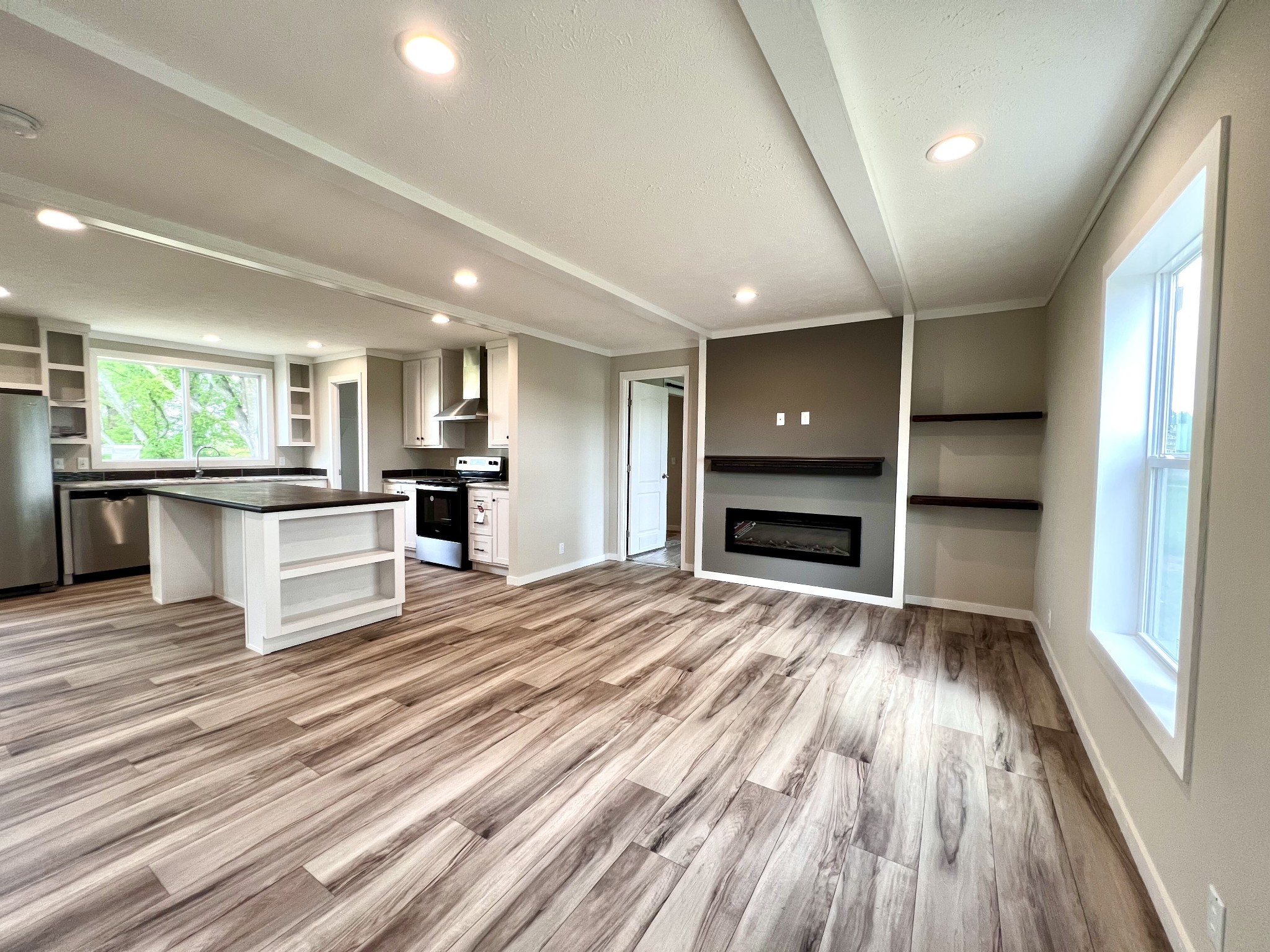 1081 McAfee Road Morrison, TN 37357 - Photo 6 of 39 an empty room with wooden floor kitchen view and windows