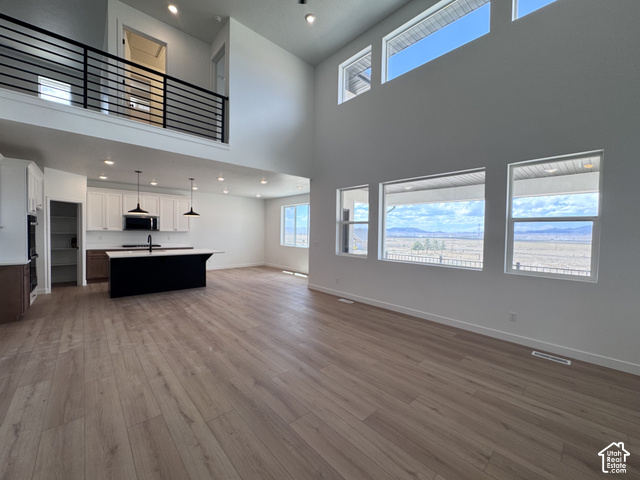 2613 Scarlet Road, Unit 258 Eagle Mountain, UT 84005 - Photo 6 of 30 Two-story living area with high ceilings, wood-finish flooring, and multiple windows