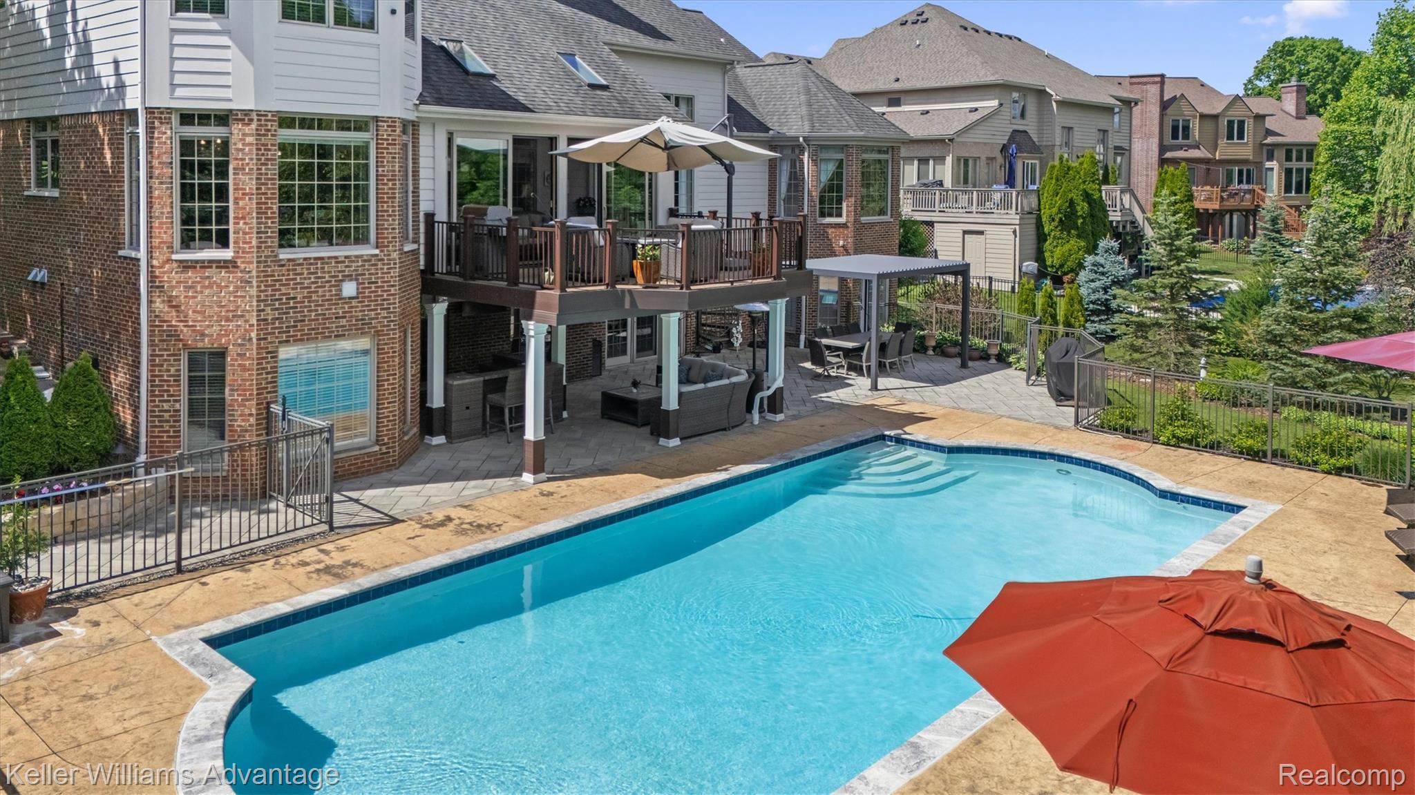 22878 Tree Top Court South Lyon, MI 48178 - Photo 47 of 75 Irregular-shaped pool with integrated steps, surrounded by a stamped concrete patio