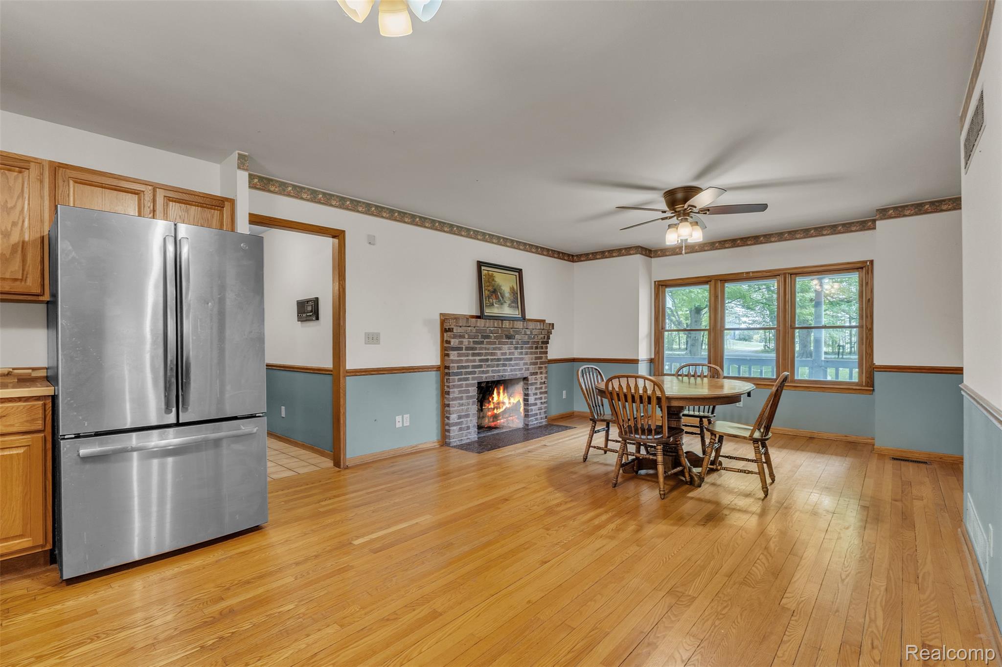 1345 Ives Road Mason, MI 48854 - Photo 24 of 92 Dining space with light wood finished floors, ceiling fan, and a brick fireplace
