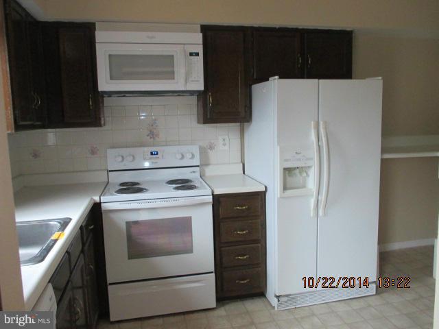 1045 Grovehill Road Baltimore, MD 21227 - Photo 7 of 27 a kitchen with a stove and a refrigerator