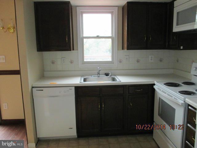 1045 Grovehill Road Baltimore, MD 21227 - Photo 8 of 27 a kitchen with a sink stove and microwave