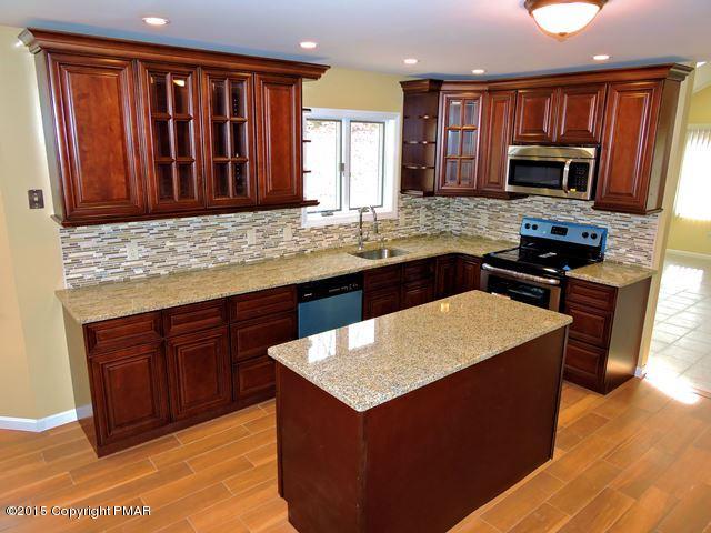 248 Pin Oak Road Stroudsburg, PA 18360 - Photo 11 of 33 a kitchen with granite countertop a sink and a stove top oven with wooden cabinets