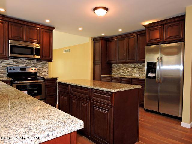 248 Pin Oak Road Stroudsburg, PA 18360 - Photo 14 of 33 a kitchen with stainless steel appliances wooden cabinets a stove a sink and a refrigerator