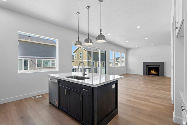 36 South Crimson Way, Unit 305 Mapleton, UT 84664 - Photo 3 of 7 Kitchen island featuring dark wood cabinetry, a white countertop, and a stainless steel sink with a gooseneck faucet