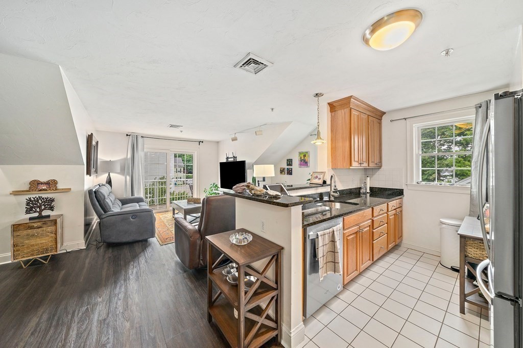 24 Wall Street, Unit E Canton, MA 02021 - Photo 1 of 1 a kitchen with stainless steel appliances granite countertop a stove a sink dishwasher and white cabinets with wooden floor