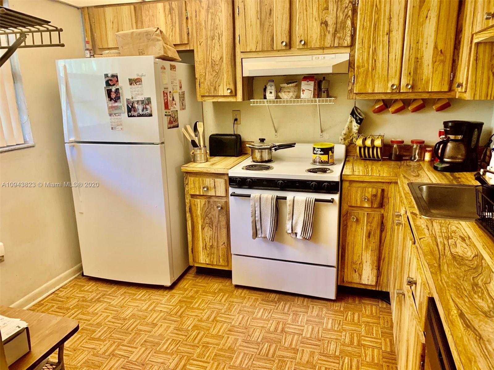 10975 Southwest 107th Street, Unit 117 Miami, FL 33176 - Photo 11 of 13 a kitchen with a stove and a refrigerator