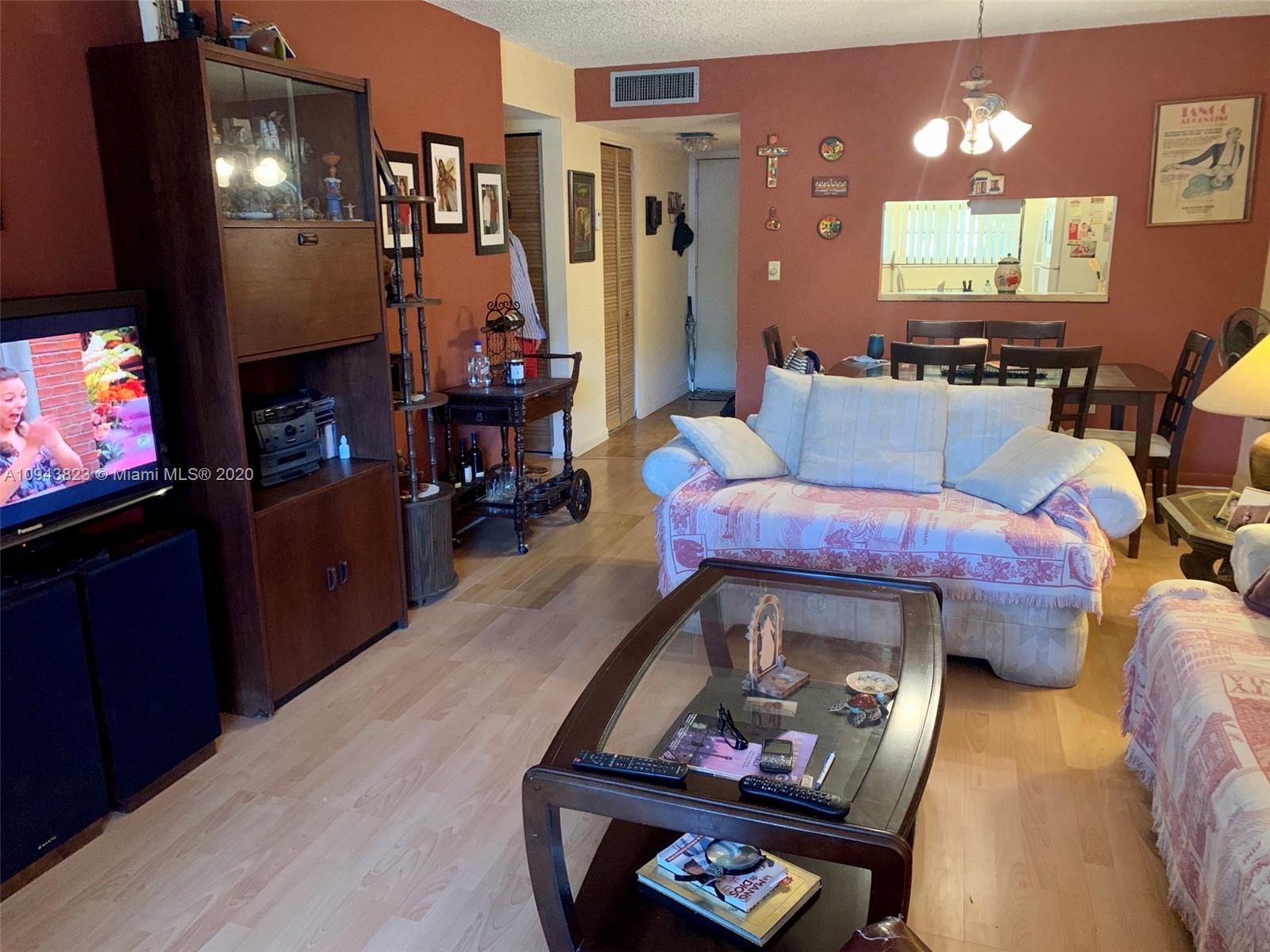 10975 Southwest 107th Street, Unit 117 Miami, FL 33176 - Photo 13 of 13 a living room with furniture and a flat screen tv