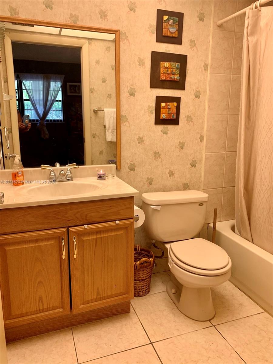 10975 Southwest 107th Street, Unit 117 Miami, FL 33176 - Photo 10 of 13 a bathroom with a toilet a sink and mirror