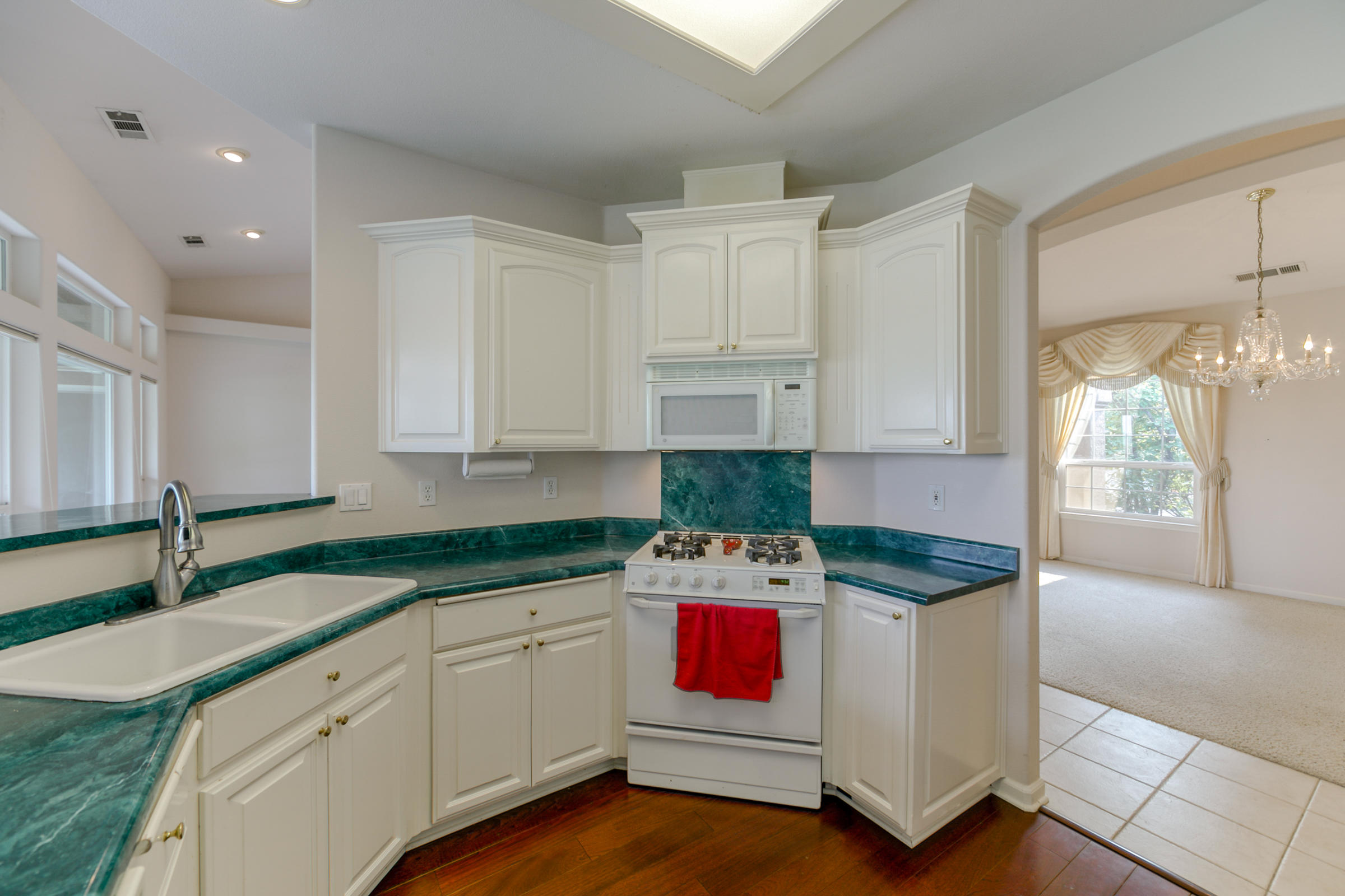 2965 Shadow Brook Lane Redding, CA 96001 - Photo 13 of 38 a kitchen with granite countertop white cabinets sink and stainless steel appliances