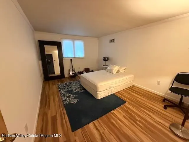 a bedroom with a bed and wooden floor