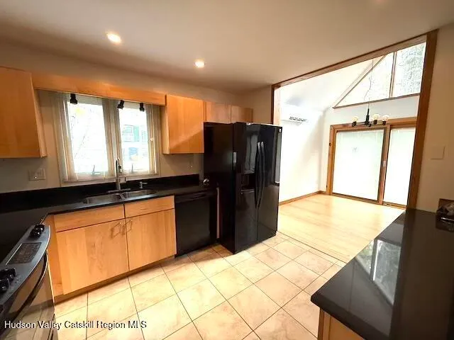 a kitchen with stainless steel appliances kitchen island granite countertop a refrigerator and a sink