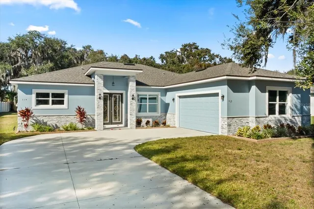 a front view of a house with a yard outdoor seating and garage