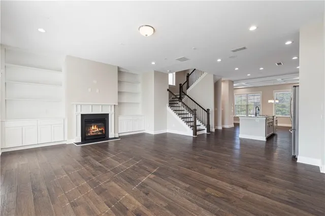 a view of empty room with wooden floor and a fireplace
