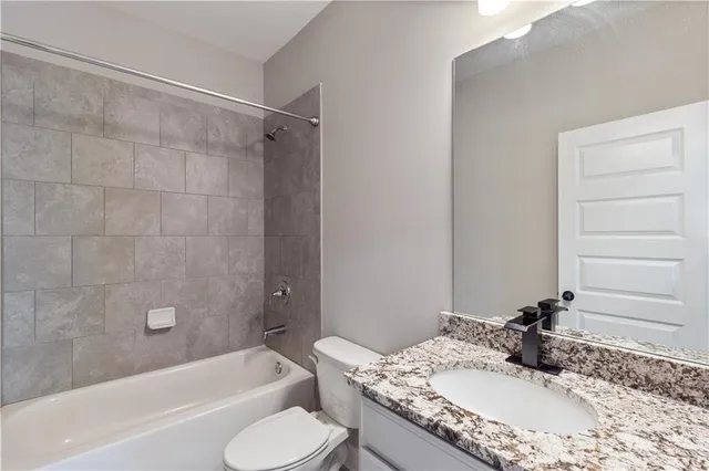 a bathroom with a granite countertop tub sink and mirror