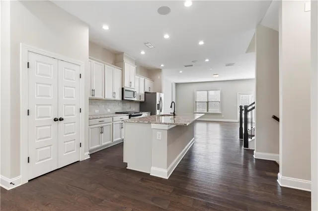a large white kitchen with white cabinets and stainless steel appliances