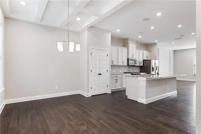 a view of kitchen with wooden floor and electronic appliances