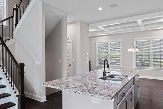 a kitchen with kitchen island granite countertop a sink and a stove