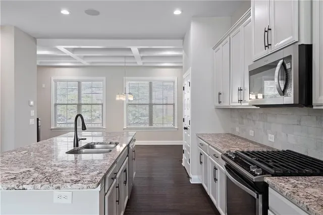 a kitchen with stainless steel appliances granite countertop a sink stove and cabinets