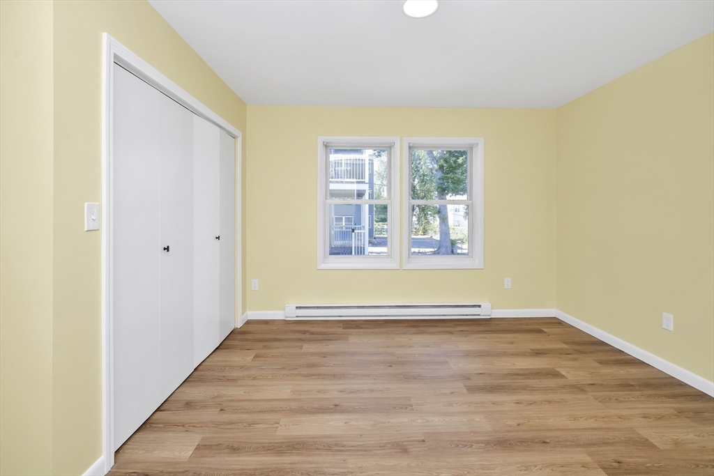 11 Greendale Road, Unit 2 Boston, MA 02126 - Photo 14 of 25 a view of an empty room with wooden floor and a window