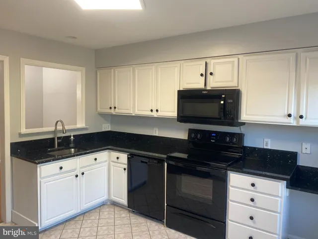 a kitchen with granite countertop a sink and a stove