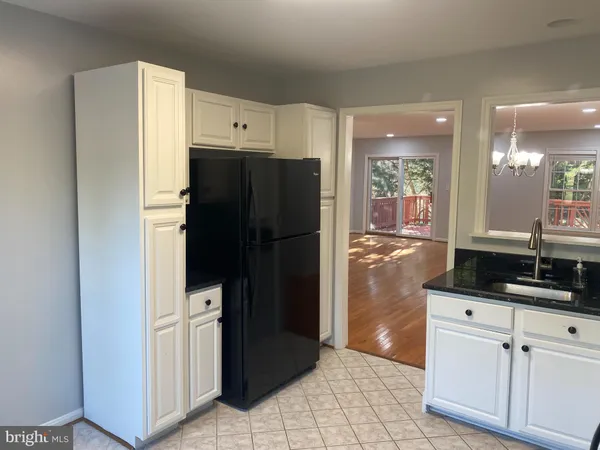 a kitchen with granite countertop a refrigerator and a sink