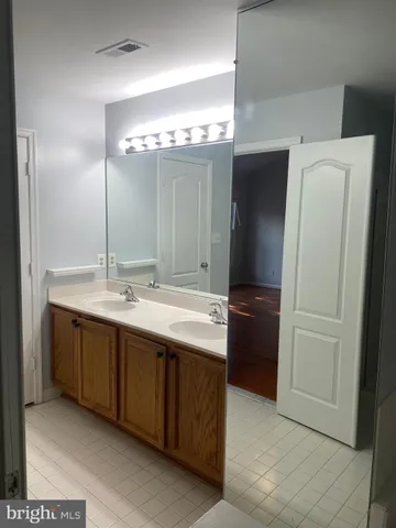 a bathroom with a double vanity sink and a mirror