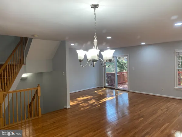 a view of a room with wooden floor and a chandelier