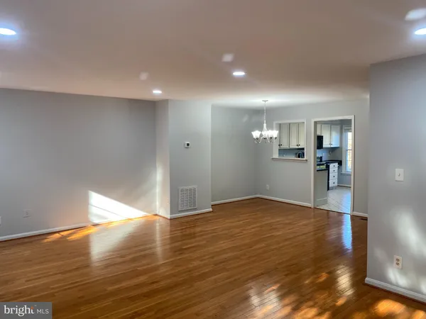 a view of a big room with wooden floor and a kitchen