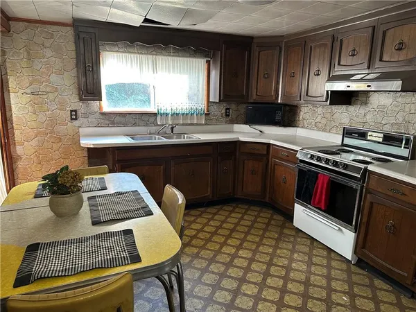 a kitchen with a stove a sink and cabinets