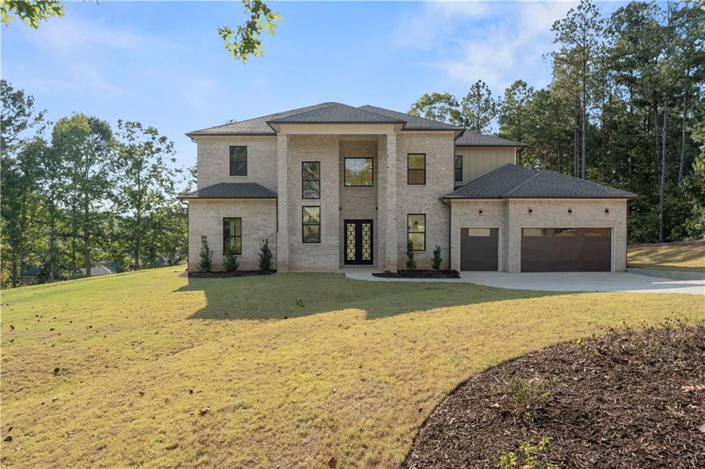 5011 Colton Run Atlanta, GA 30349 - Photo 3 of 12 a front view of a house with a yard and garage