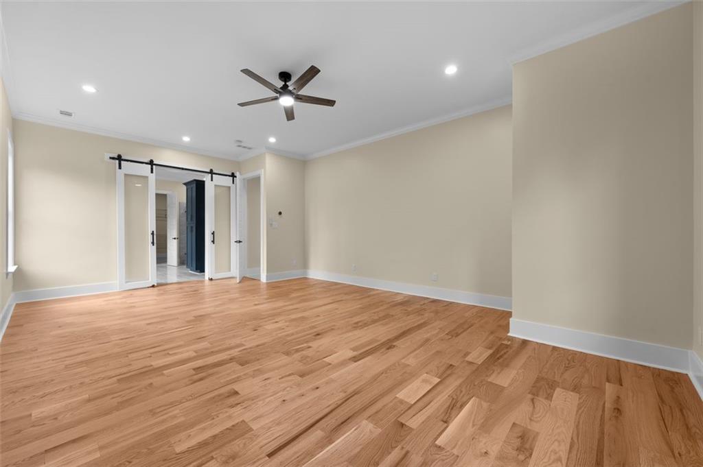5011 Colton Run Atlanta, GA 30349 - Photo 6 of 12 a view of an empty room with wooden floor and a ceiling fan