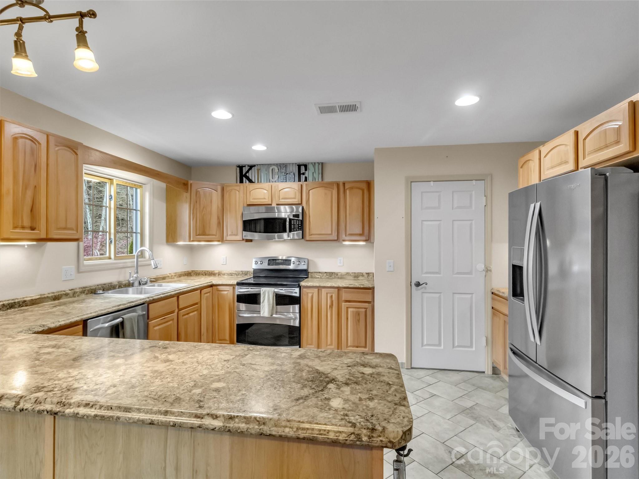 115 Fugitive Run Sylva, NC 28779 - Photo 12 of 47 a kitchen with stainless steel appliances granite countertop a refrigerator a stove top oven a sink and dishwasher