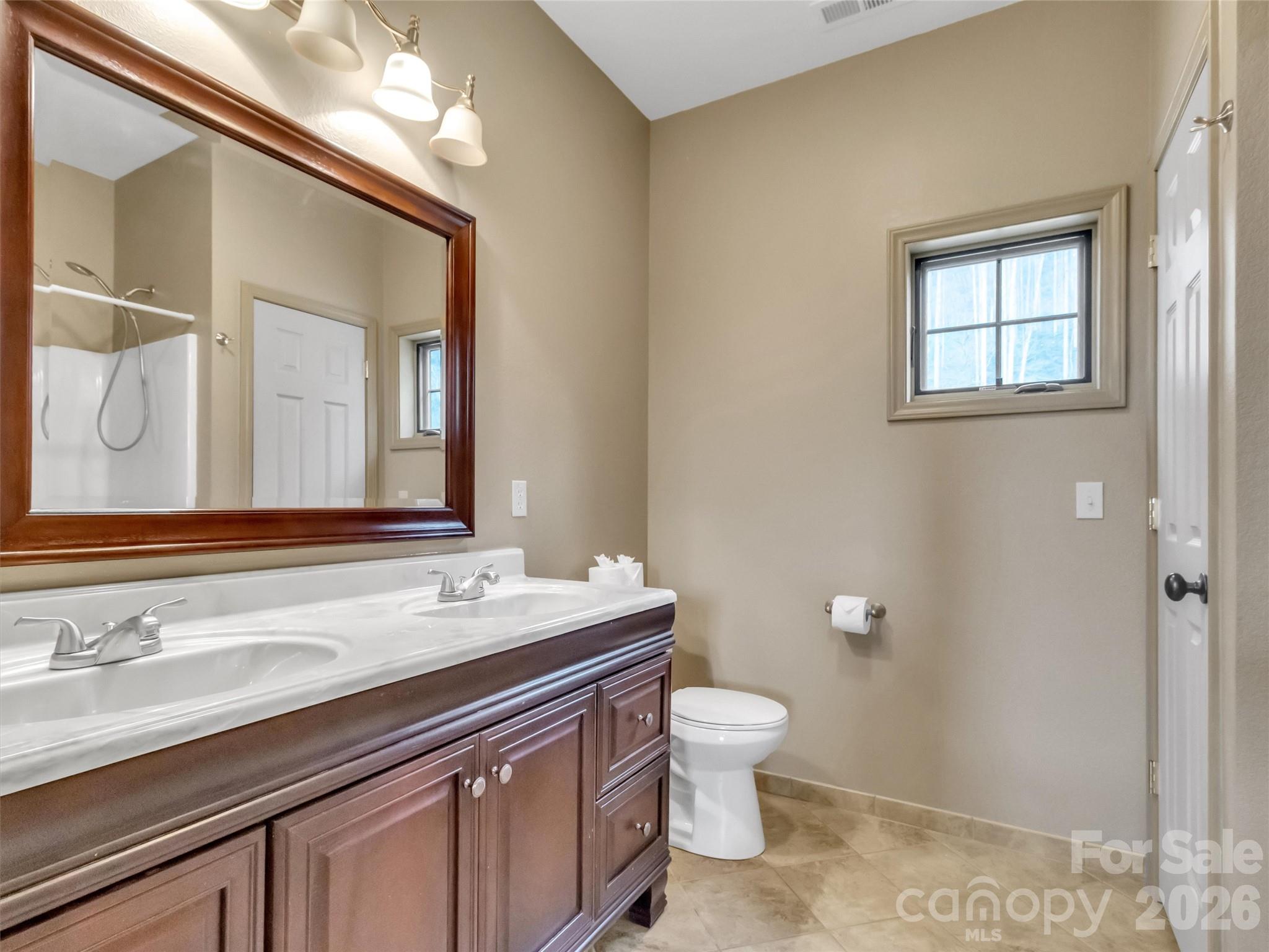 115 Fugitive Run Sylva, NC 28779 - Photo 22 of 47 a bathroom with a granite countertop sink a toilet and a mirror