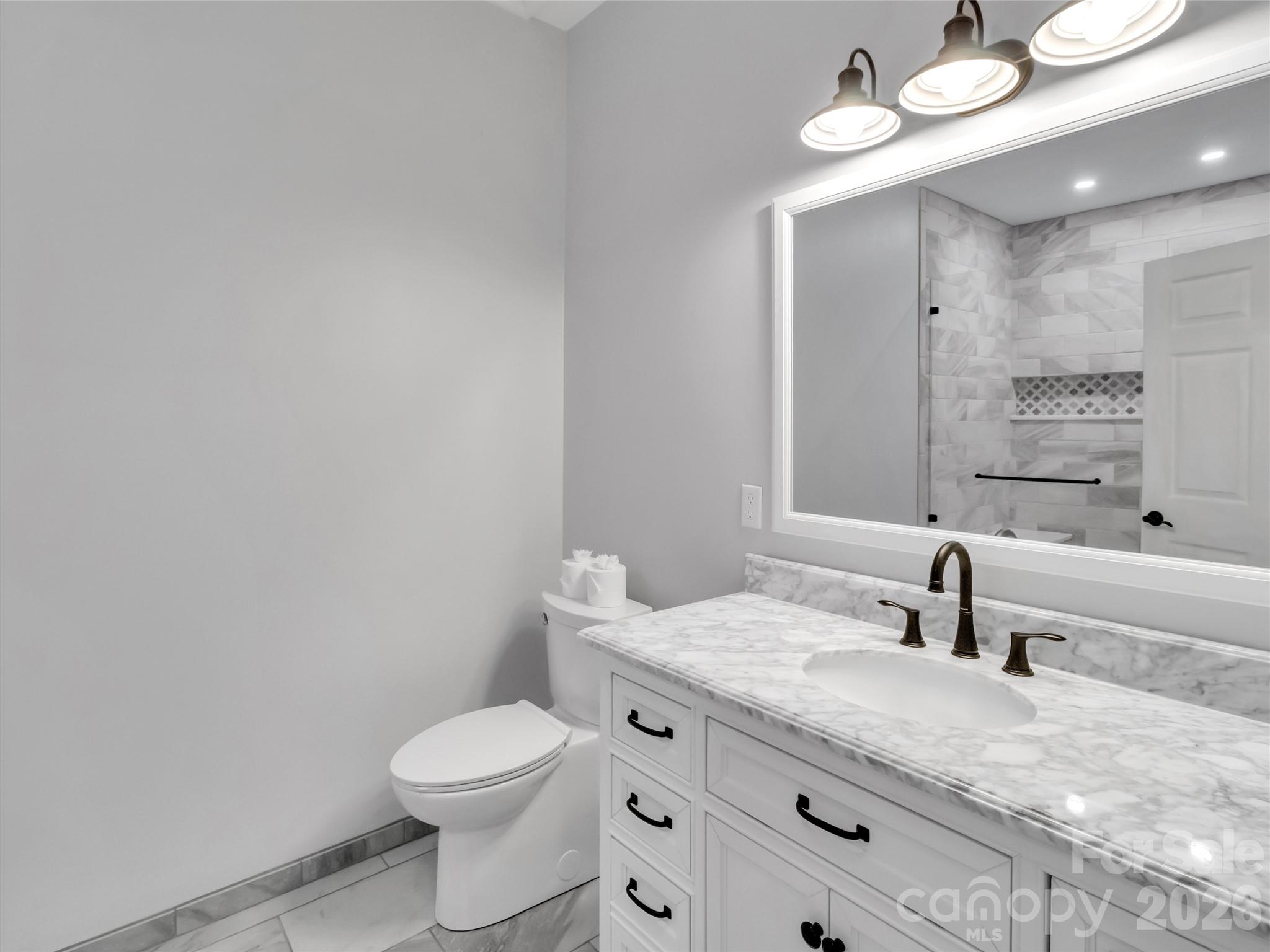 115 Fugitive Run Sylva, NC 28779 - Photo 32 of 47 a bathroom with a granite countertop sink a toilet and a mirror