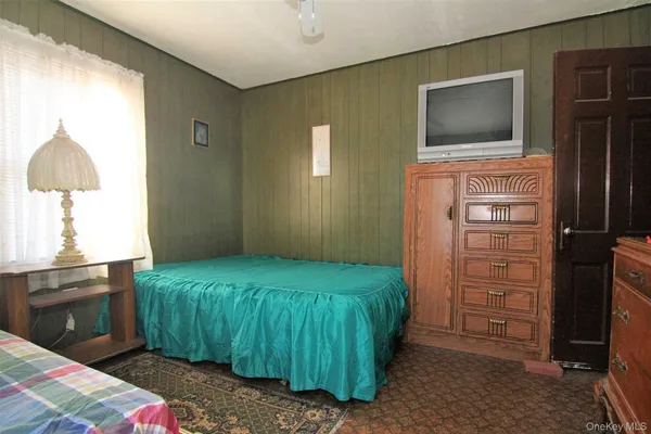 a bedroom with a bed and a television