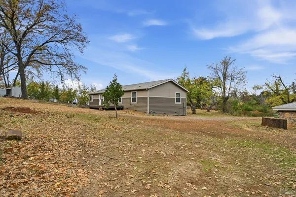 a front view of a house with a yard and trees