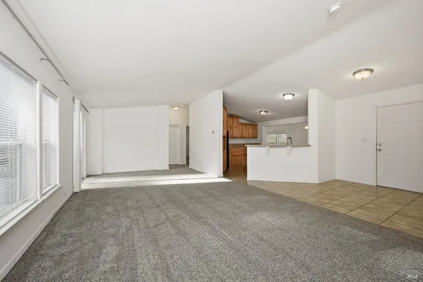 a view of a big room with wooden floor and windows